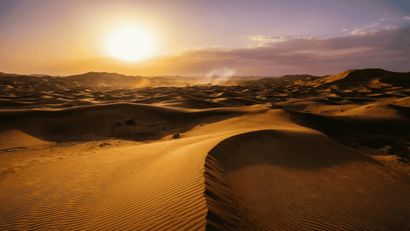 Route caravanière dans le désert du Sahara au coucher du soleil, dunes de sable à perte de vue