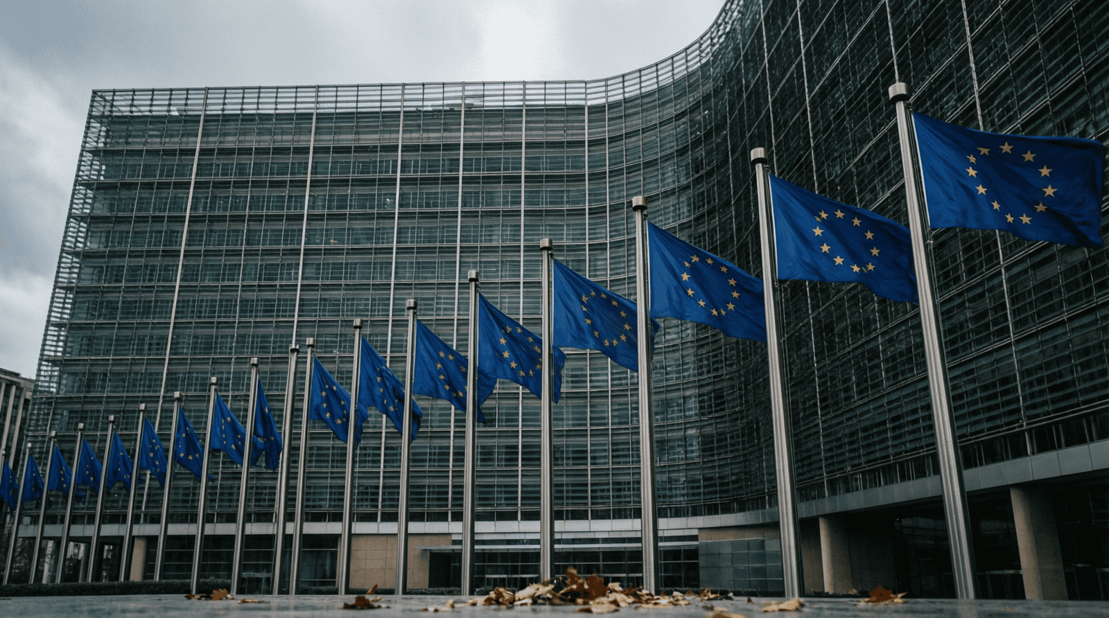 Drapeaux de l'Union européenne devant un immeuble moderne, certains en berne, ciel nuageux