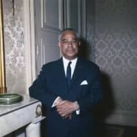 Gaston Monnerville, président du Sénat, en costume sombre dans un salon officiel